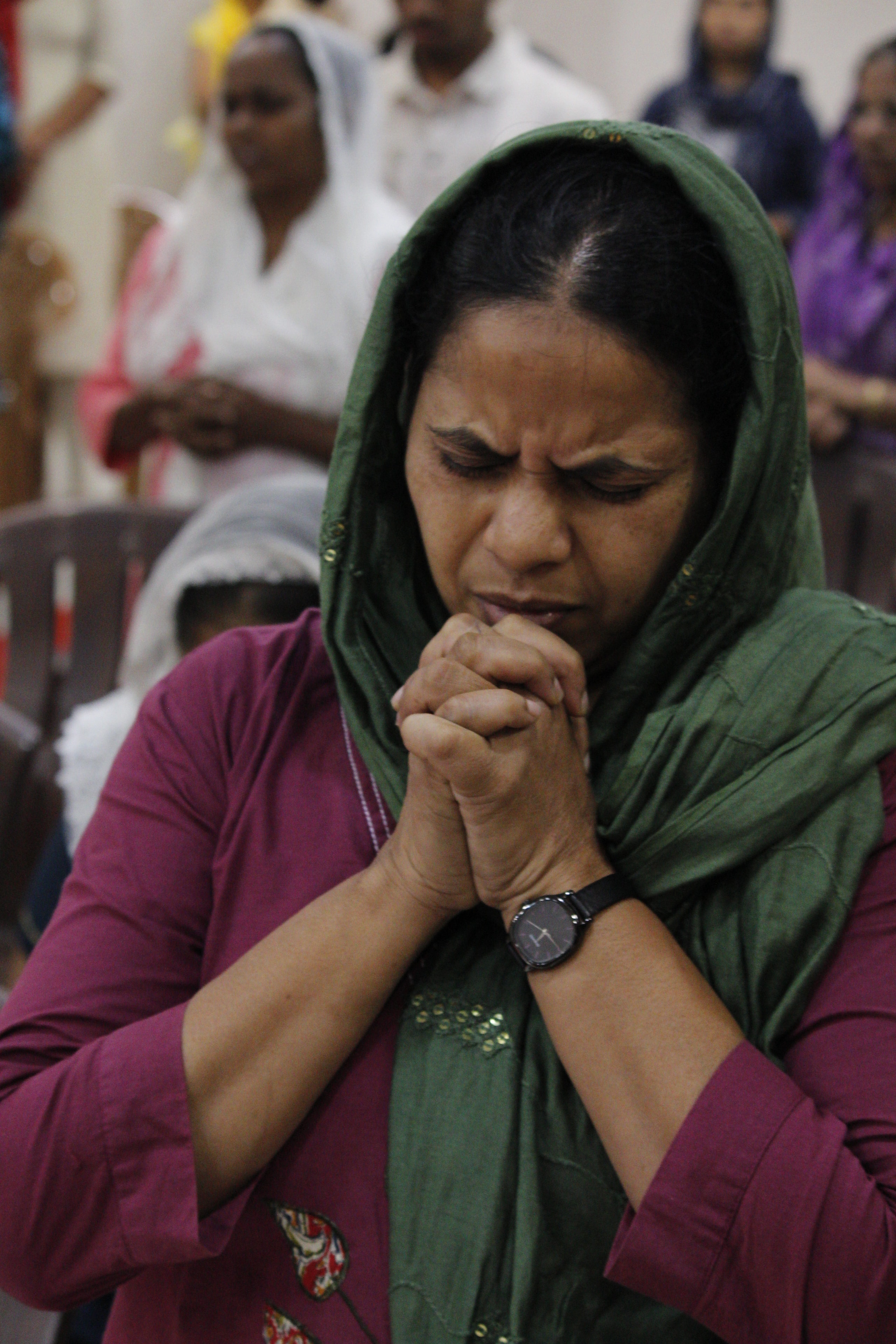 Woman in fervent prayer at a BFN ministry gathering